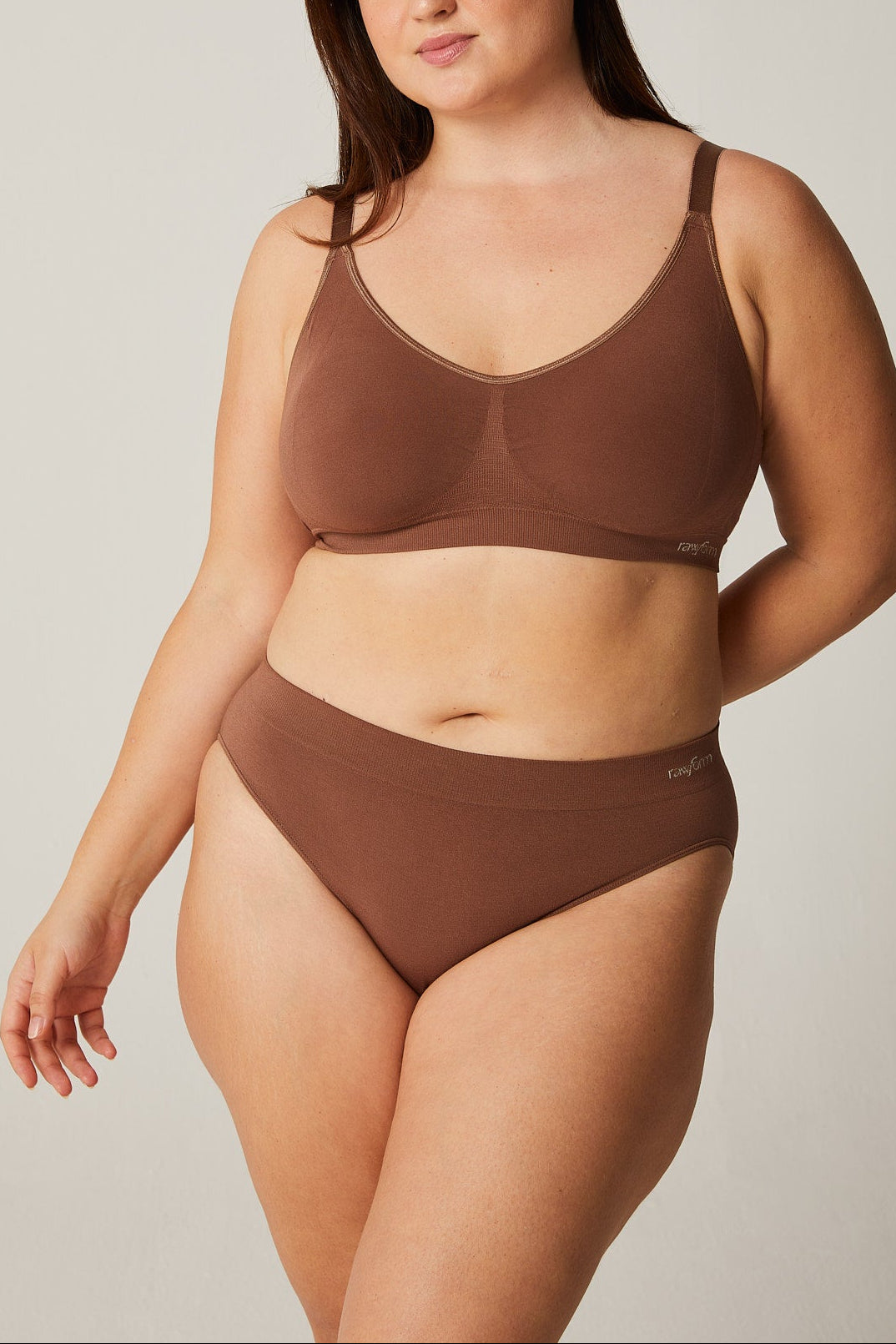 Woman wearing a brown bikini set against a plain background