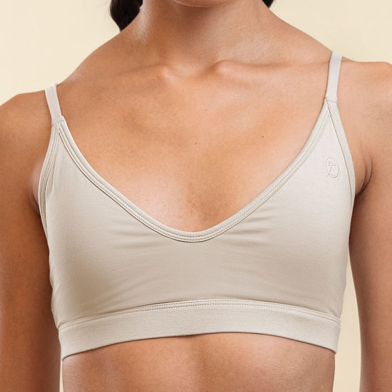 Woman wearing a beige sports bra against a plain background
