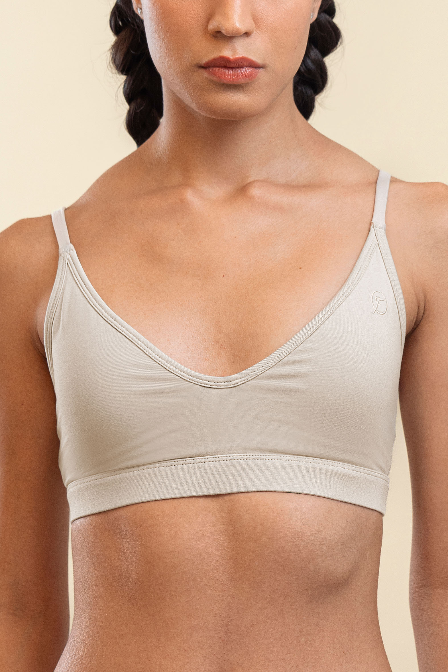 Woman wearing a beige sports bra against a plain background