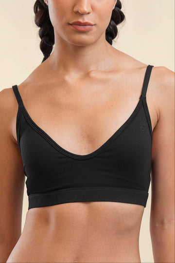 Black sports bra worn by a person on a beige background
